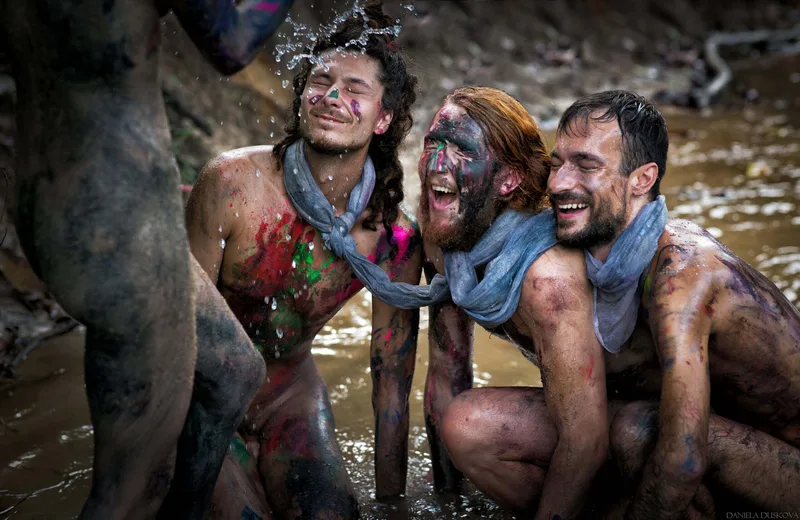Participants laughing with mud and painted faces